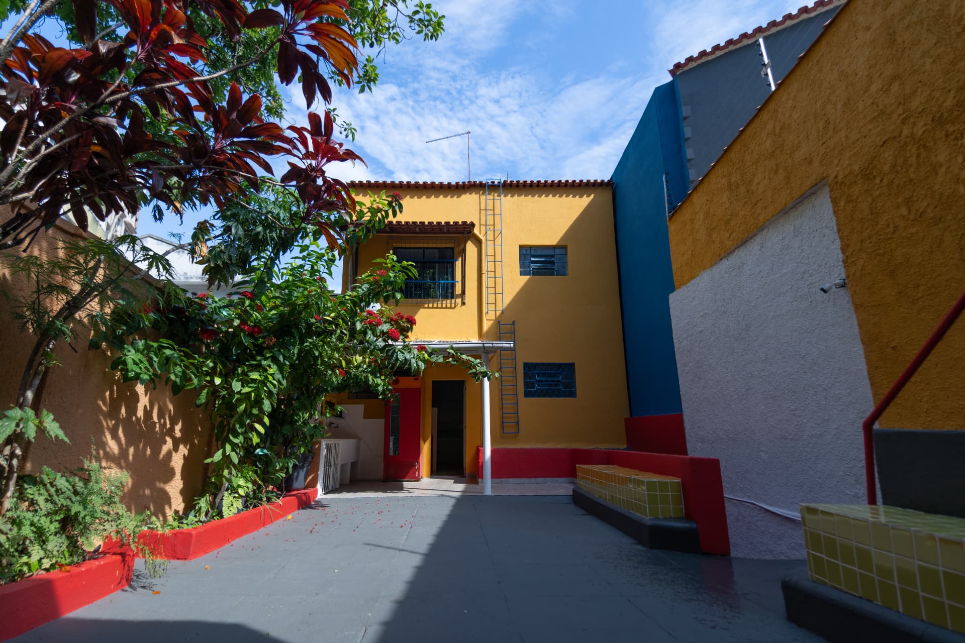 Fachada amarela da sede da MOLAA vista do pátio